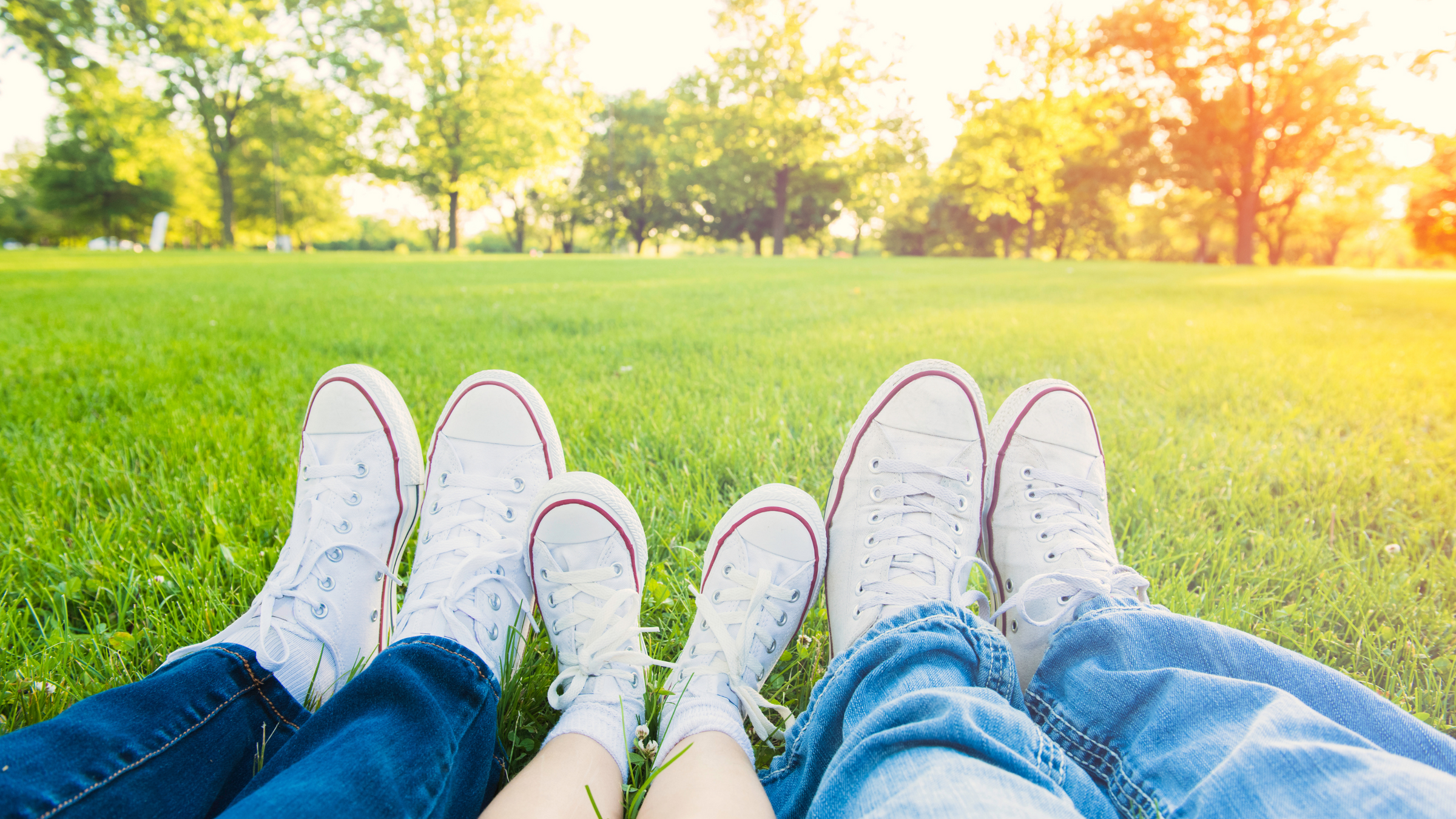 family lying in the grass wearing matching white shoes