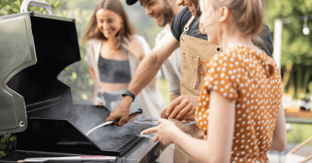 family laughing in the garden as they start up charcoal bbq