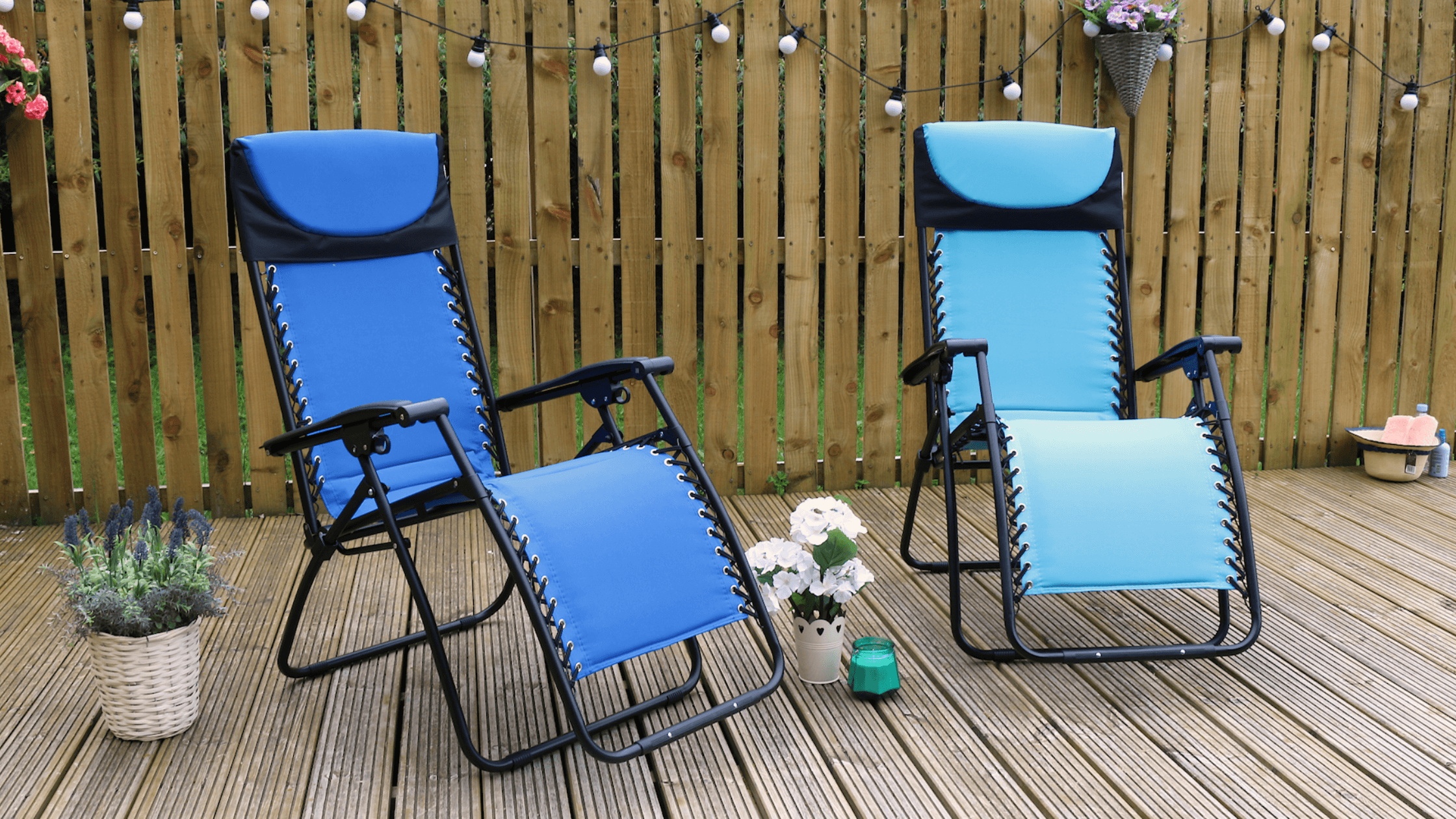 grey zero gravity relaxer chair on patio space with flowers to the side