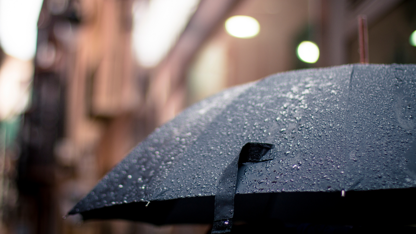 close up of black umbrella in outdoor setting with rain droplets