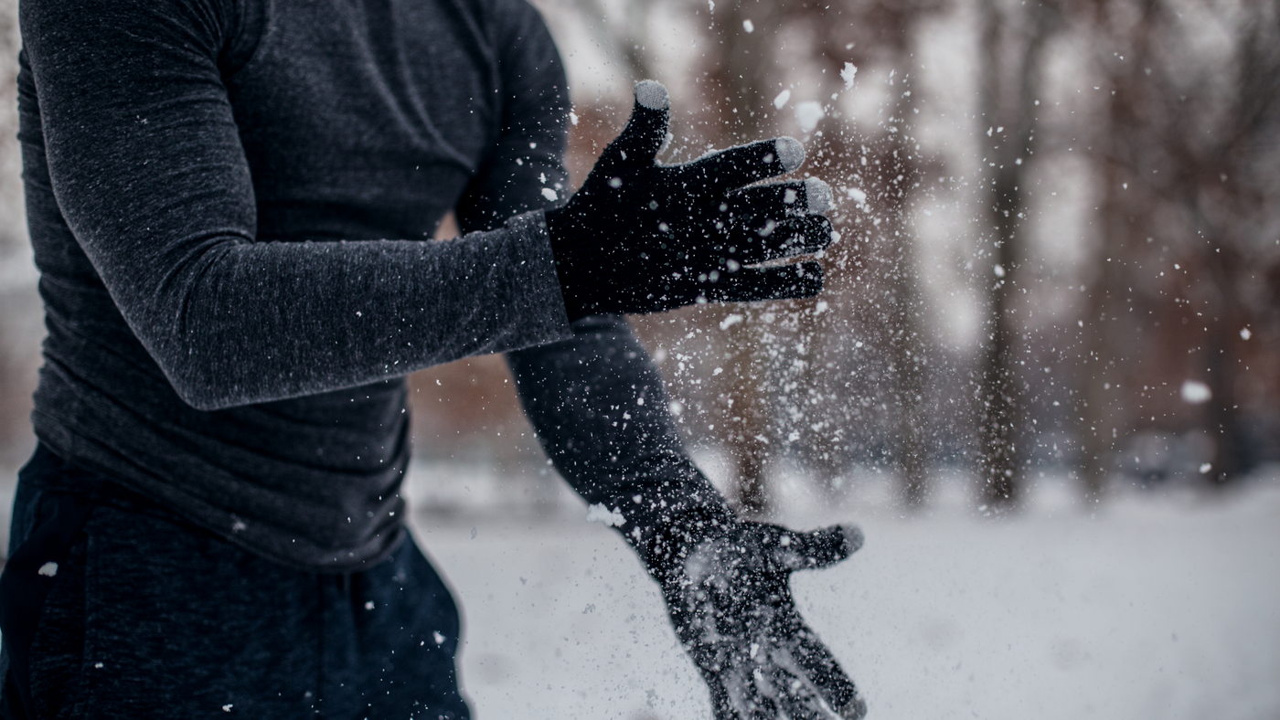man wearing black gloves with snow 