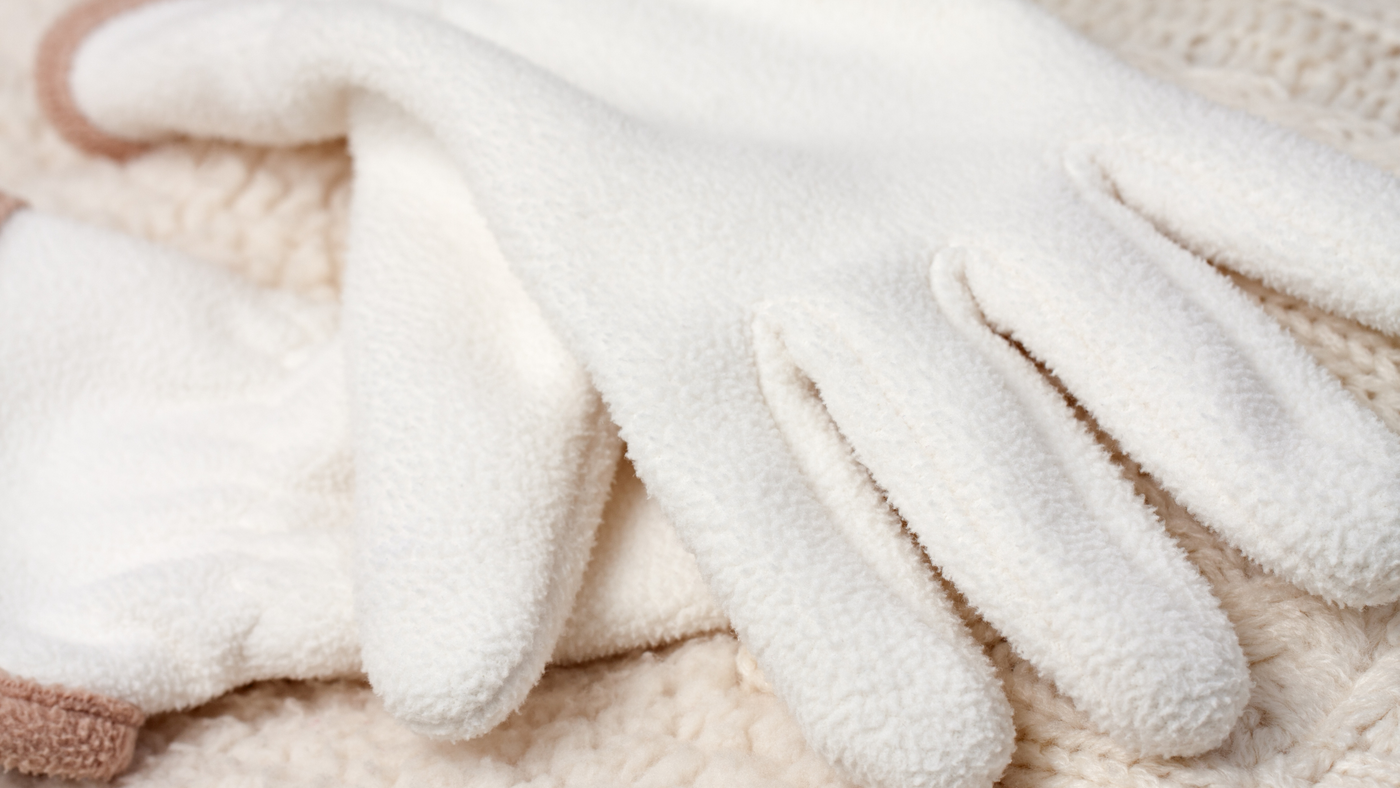 close up of white and beige coloured fluffy winter gloves