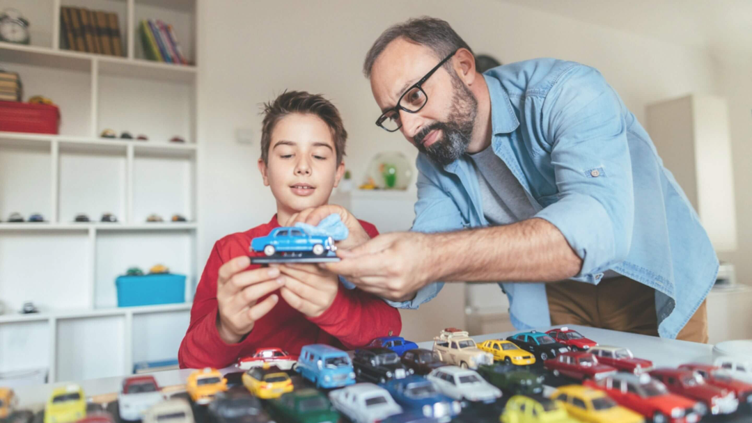 dad and son inspecting and playing with their collection of collectible cars