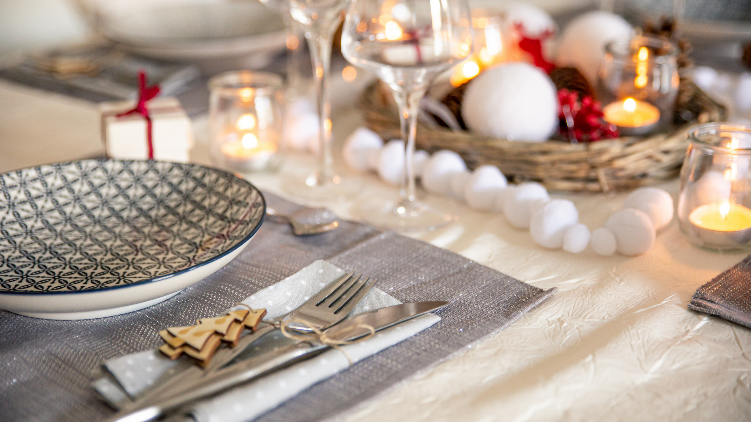 christmas table set up with white table clover, grey glitter place mat and tea light candles