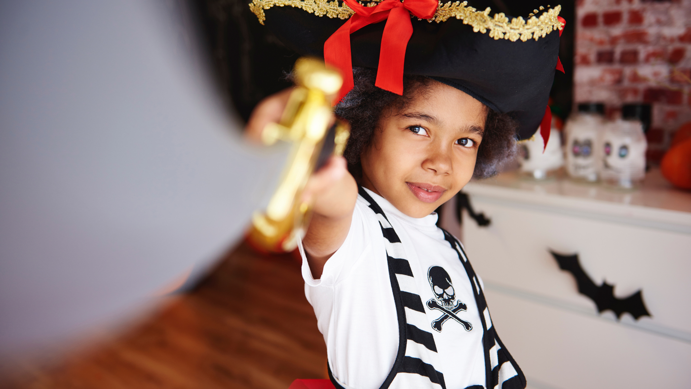 little girl dressed as a pirate and holding her sword close to the camera lens