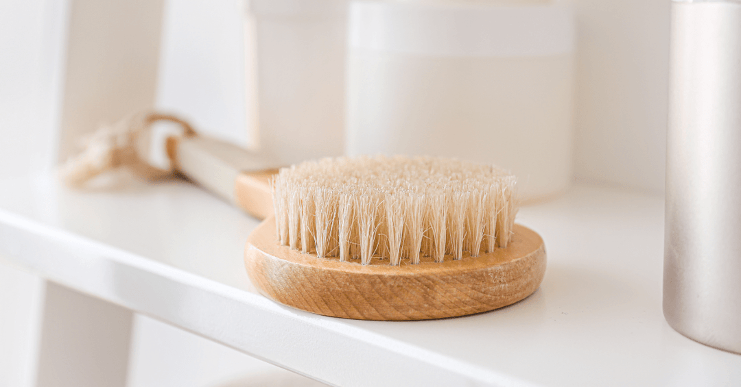 exfoliating back scrubber resting on bathroom shelf