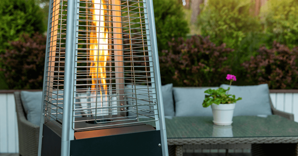 gas patio pyramid heater with flames in front of grey rattan furniture set