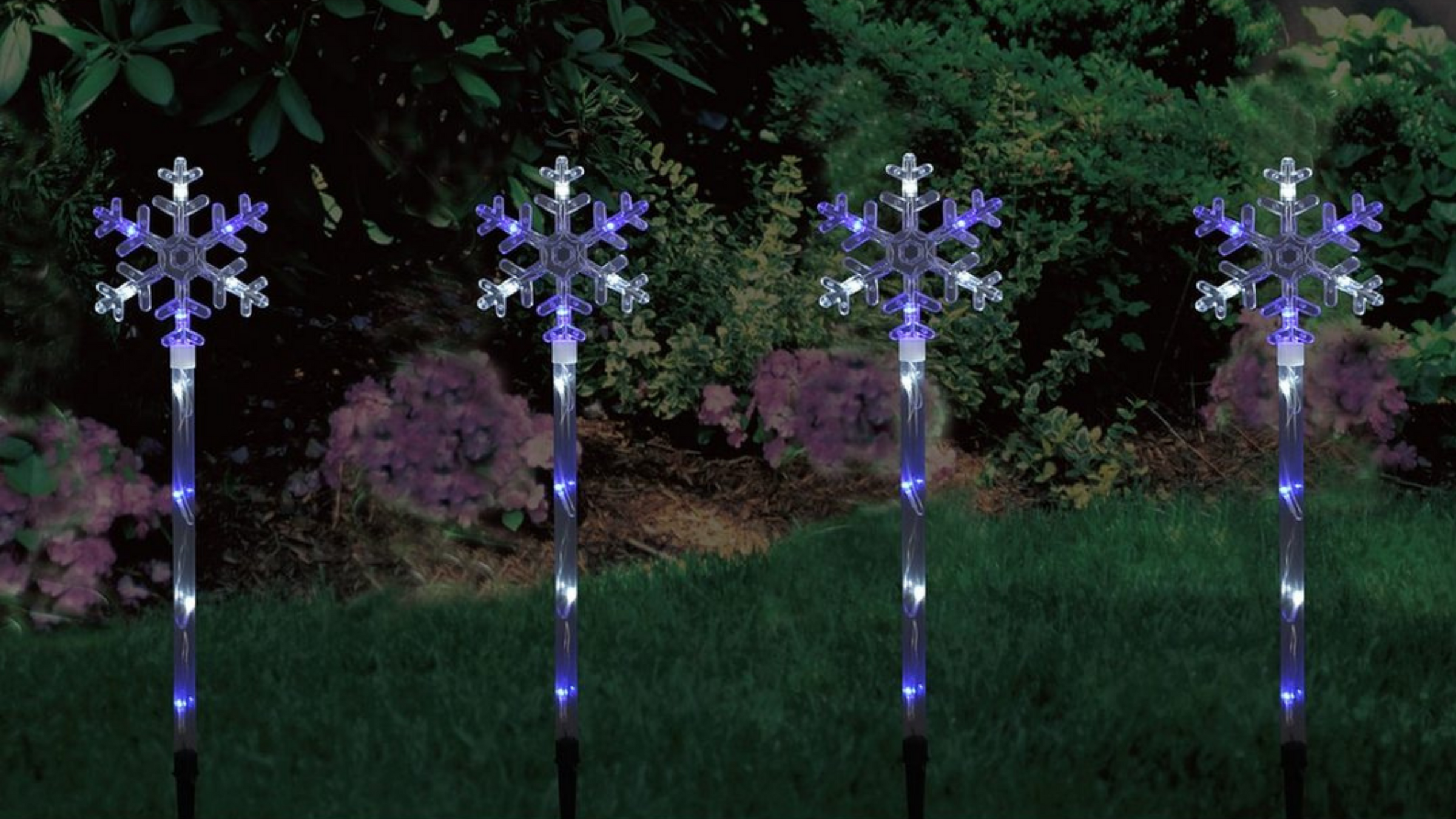 set of 4 snowflake lights in grass in garden