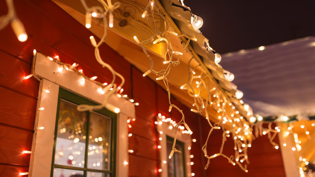 icicle lights hanging from roof of home at night