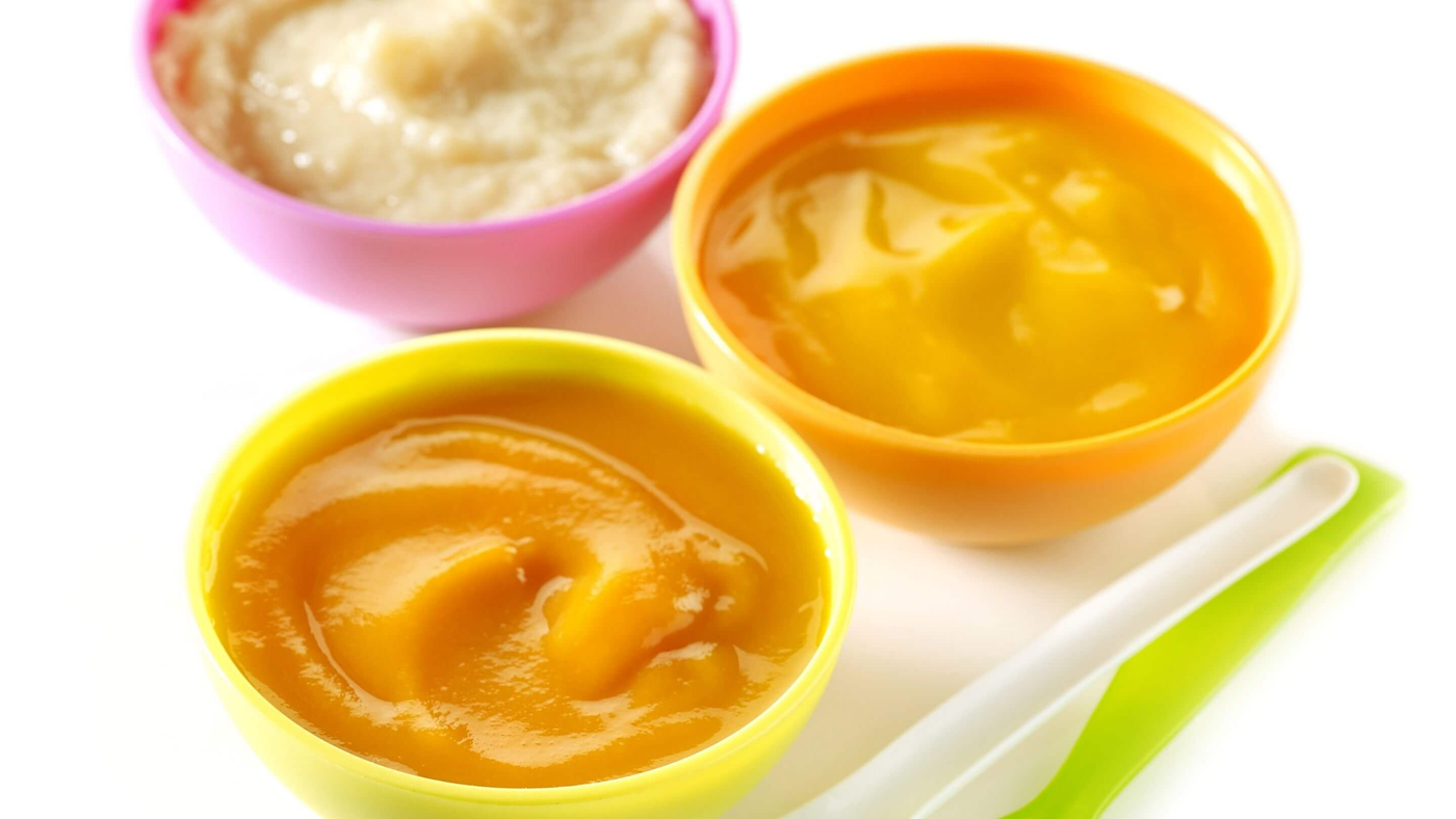 baby food containers filled with baby food and plastic spoons to the side