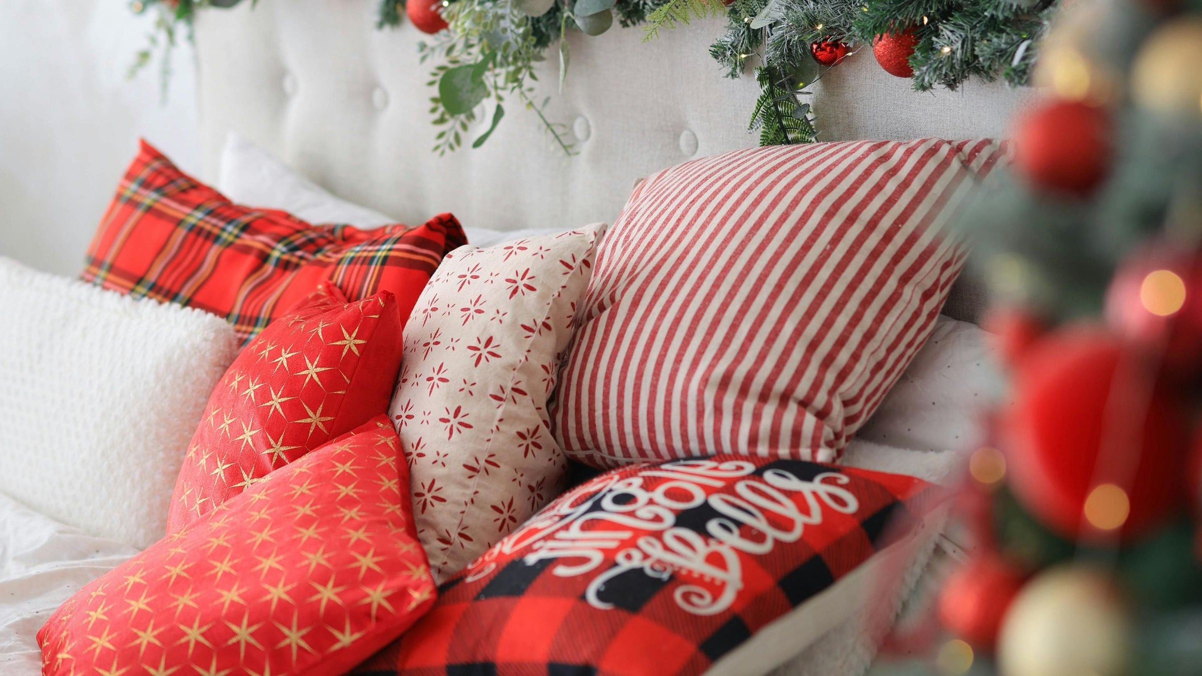 red and white cushions and blankets on white sofa