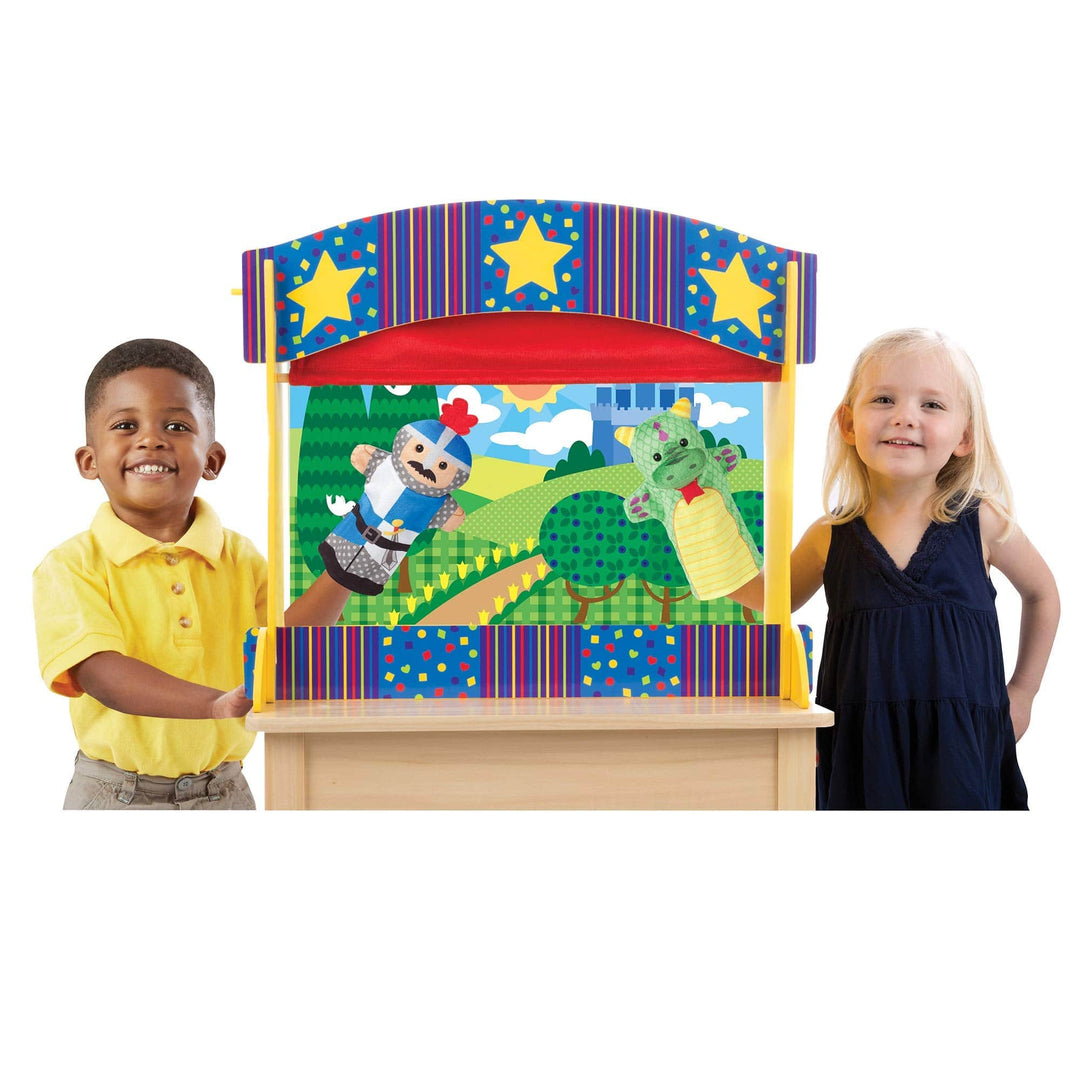 young boy and girl use puppets inside puppet theatre