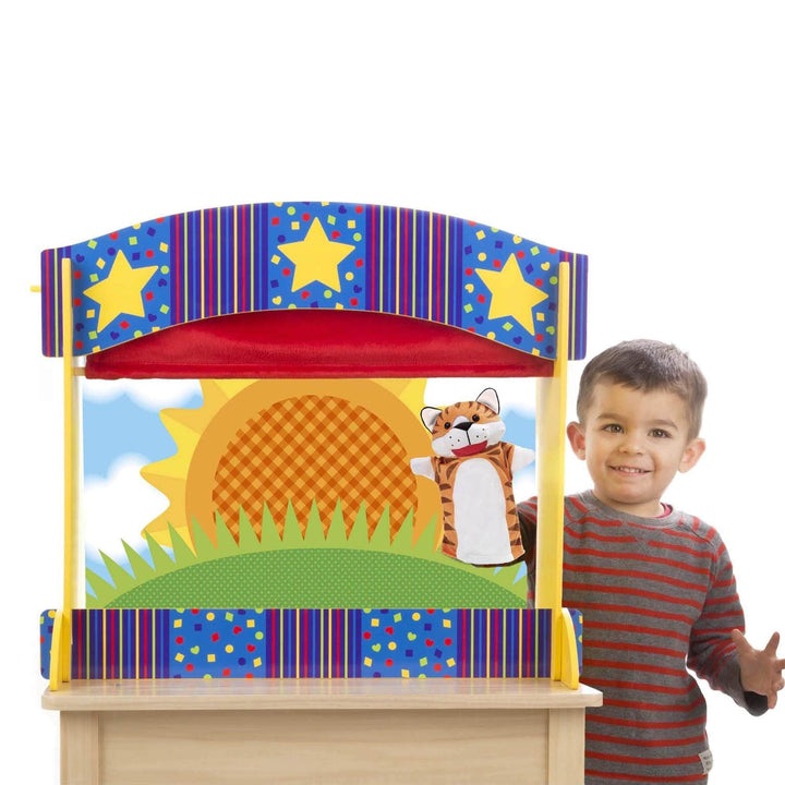 little boy holds tiger puppet inside puppet theatre with sunshine backdrop