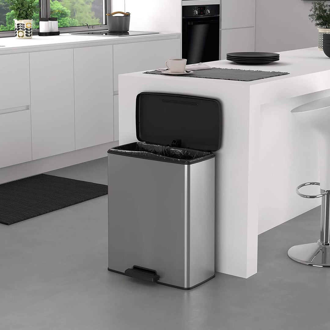 Silver pedal bin with lid open in a kitchen with white units