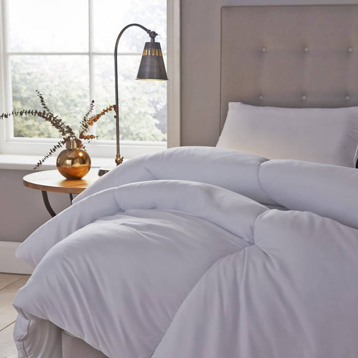 double quilt on a bed with lamp and bedside table