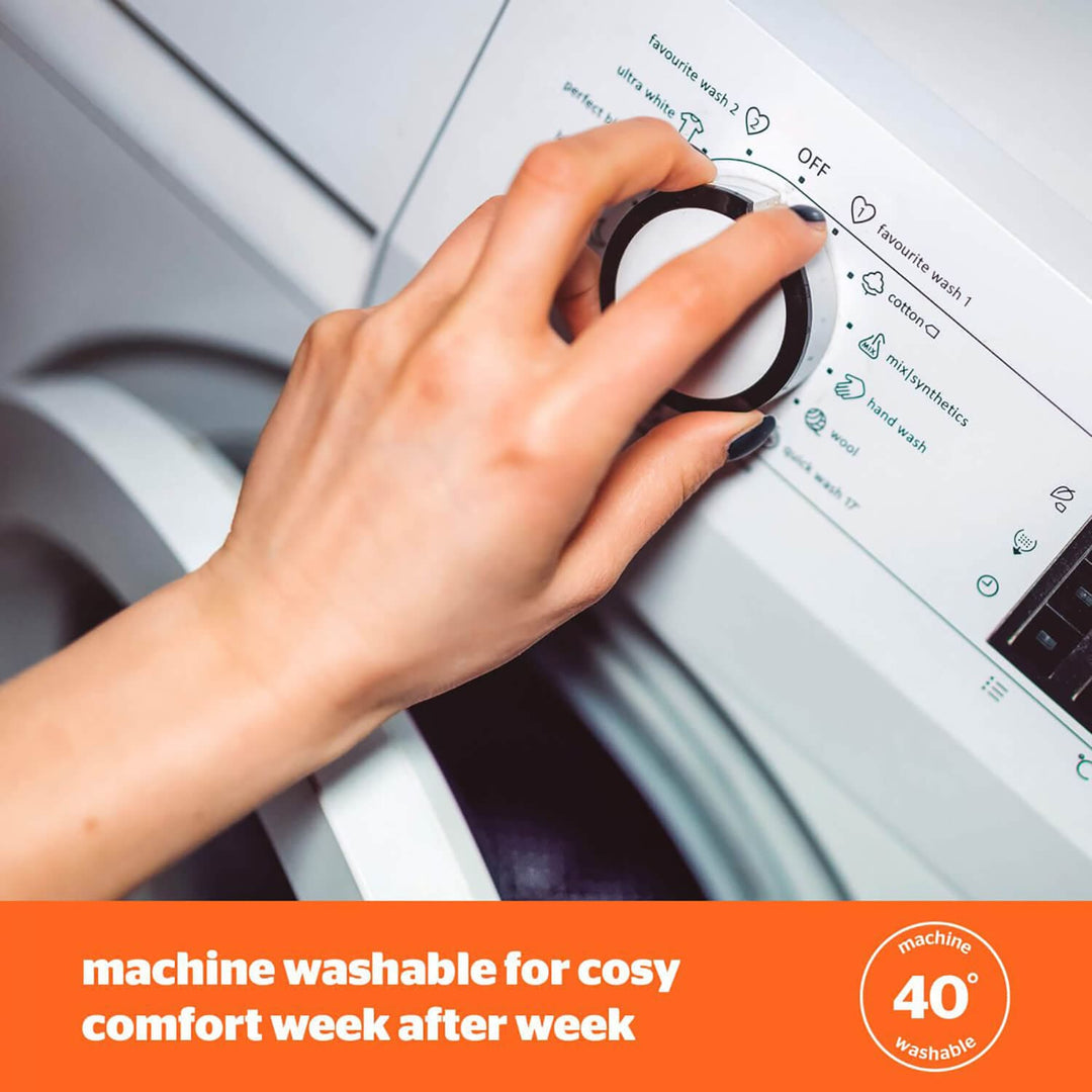 Hand turning the dial on a washing machine