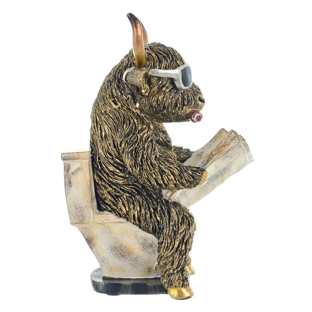 Side view of a decorative funny figure of a highland cow sitting on a toilet