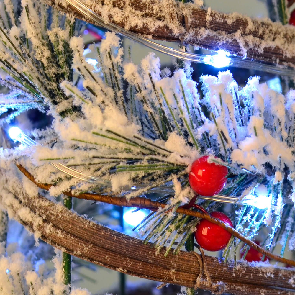 Close up of red berries on a frosted tree with white LED lights