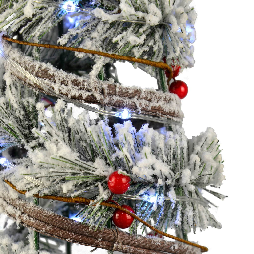 White flocked branches and red berries on an artificial Christmas tree