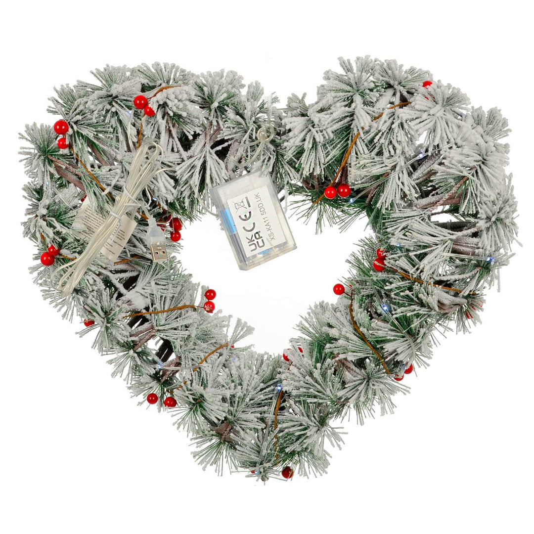 Back of a light up Christmas heart shaped wreath with red berries and battery compartment