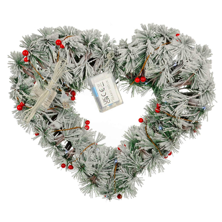 Back of a light up Christmas heart shaped wreath with red berries and battery compartment