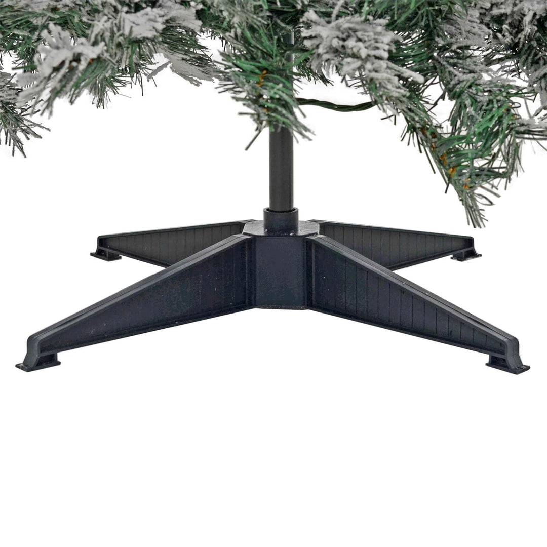 Close up of the base of an artificial Christmas tree with frosted branches