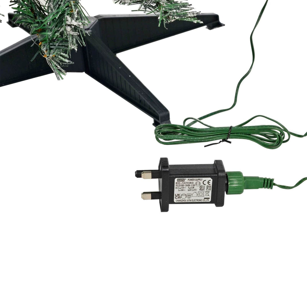 Mains transformer with green wire beside a Christmas tree stand