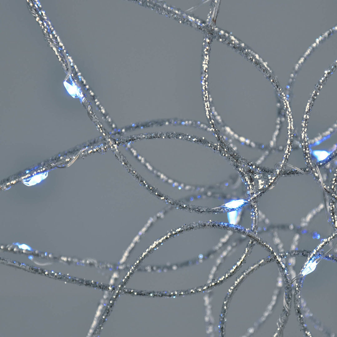 Close up of a silver glitter frame tree topper with ice white LED lights