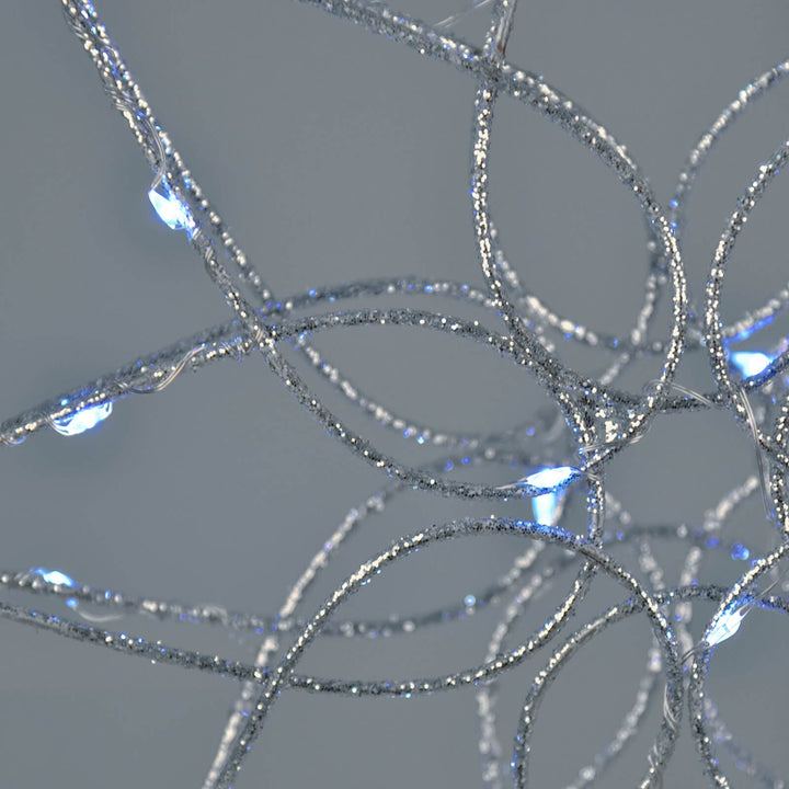 Close up of a silver glitter frame tree topper with ice white LED lights