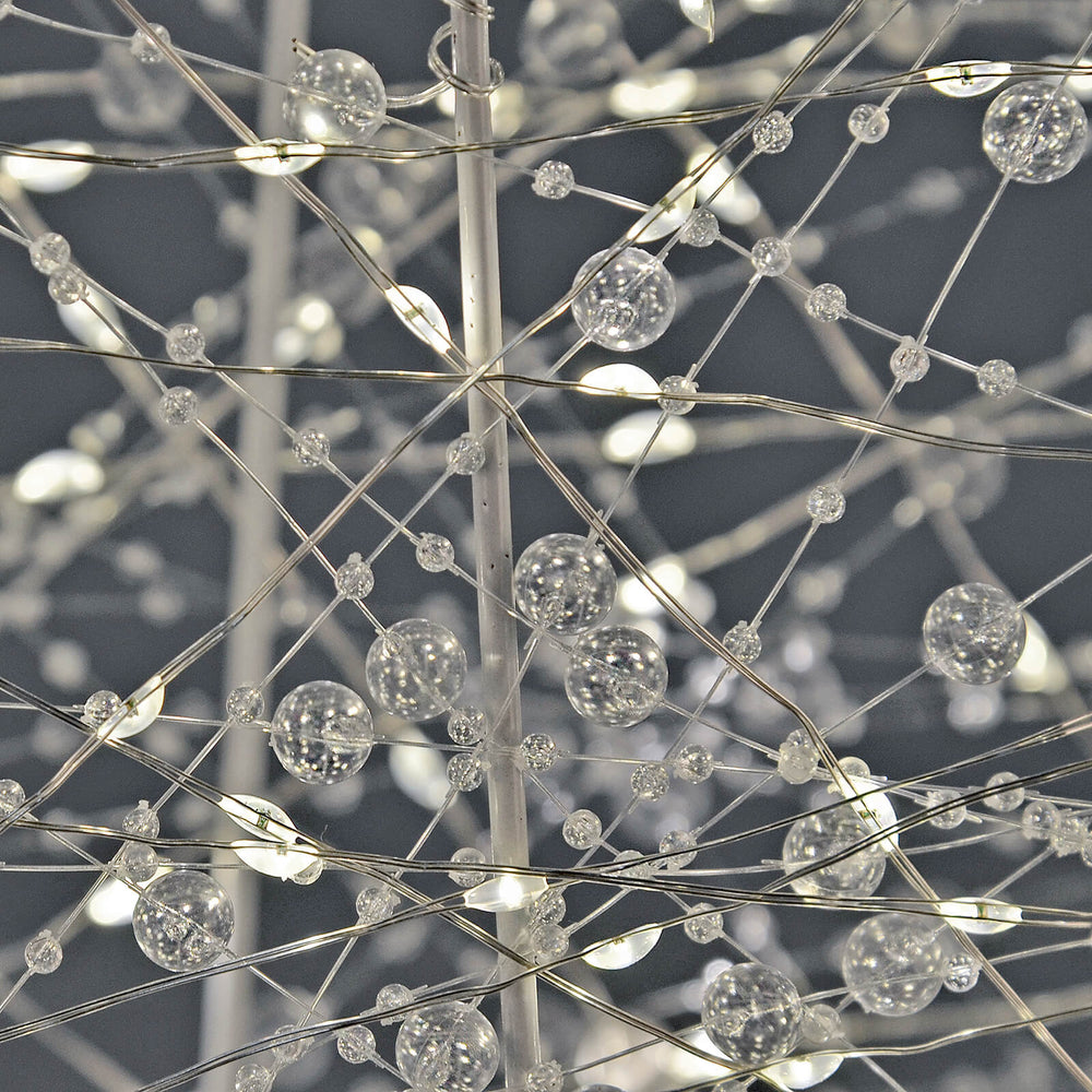 Close up of beads and LED lights on a white wire frame Christmas tree
