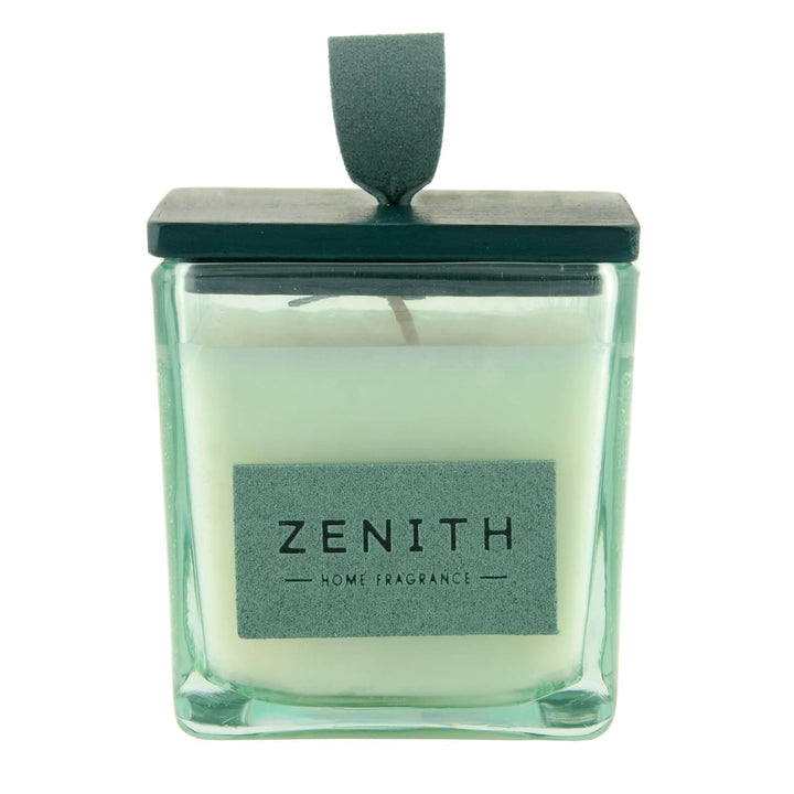Candle in a glass container with a green lid and 'Zenith' label on a white background