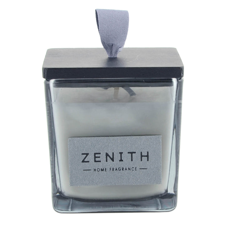 Candle in a glass container with a black lid labeled &