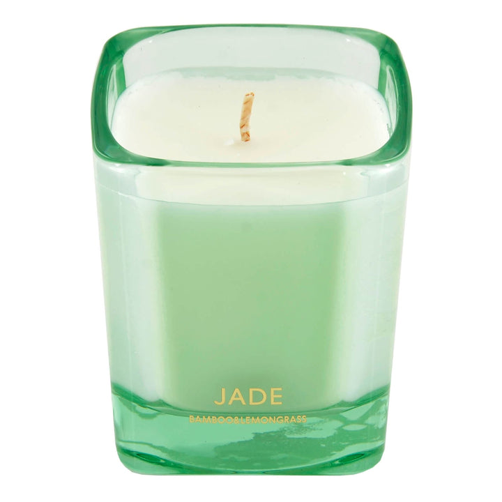 Green candle in a glass container with &