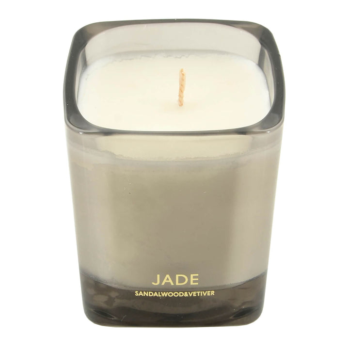 Candle in a grey glass holder labeled &