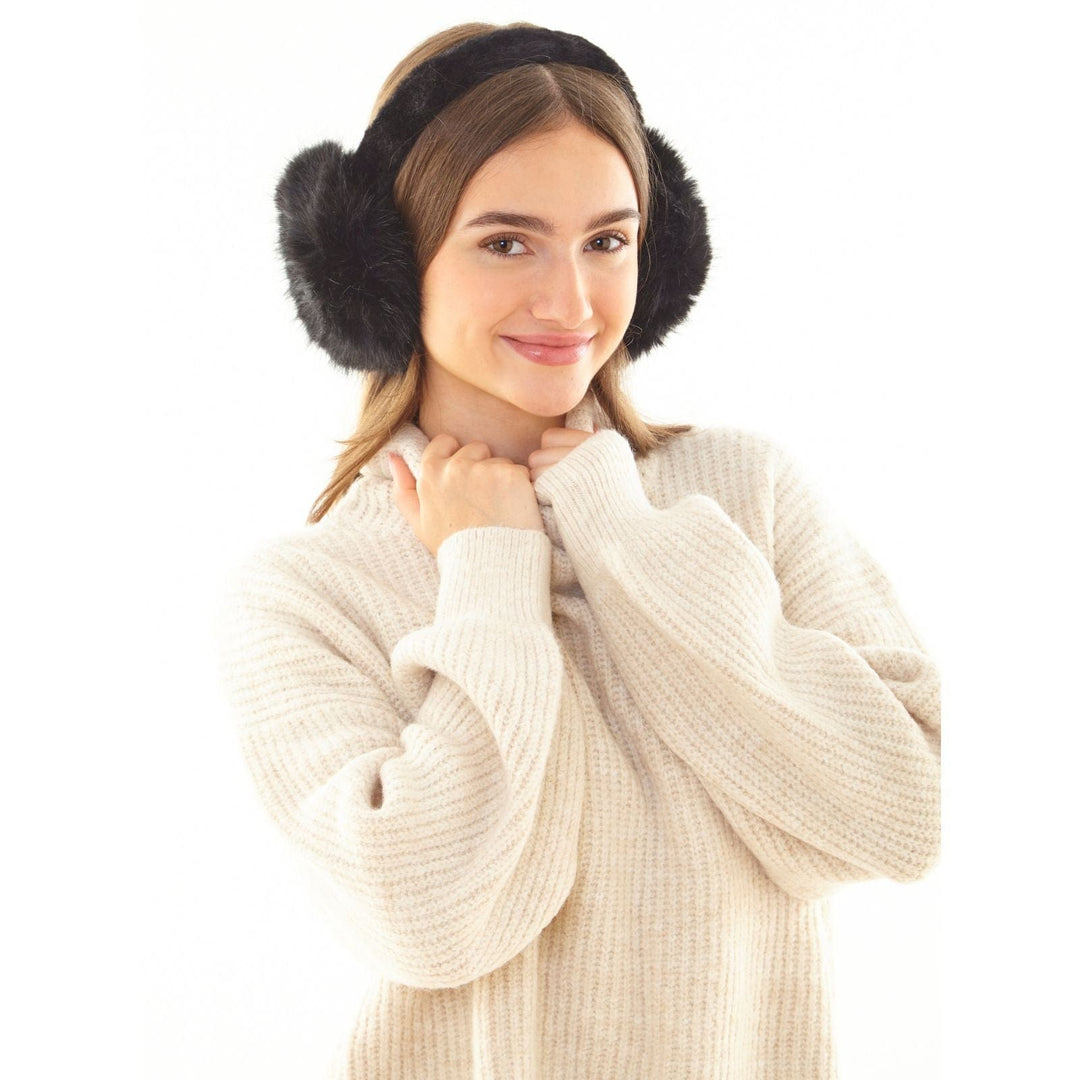 Woman wearing black fur-trimmed ear muffs on a white background