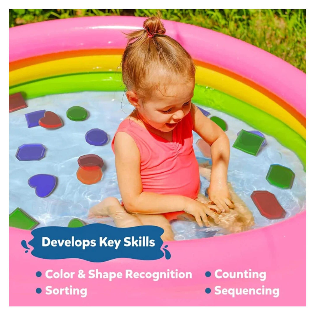 Girl sitting in a rainbow colour paddling pool with gem to find