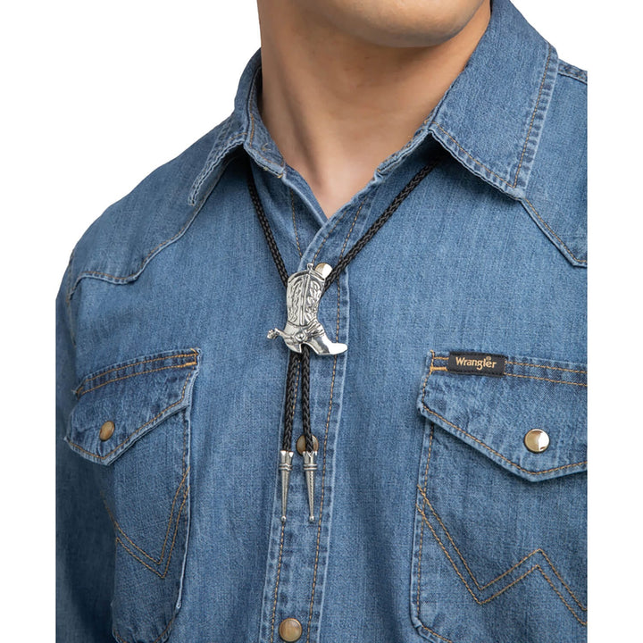 Close-up of a person wearing a blue denim shirt with a decorative cowboy boot  bolo tie.
