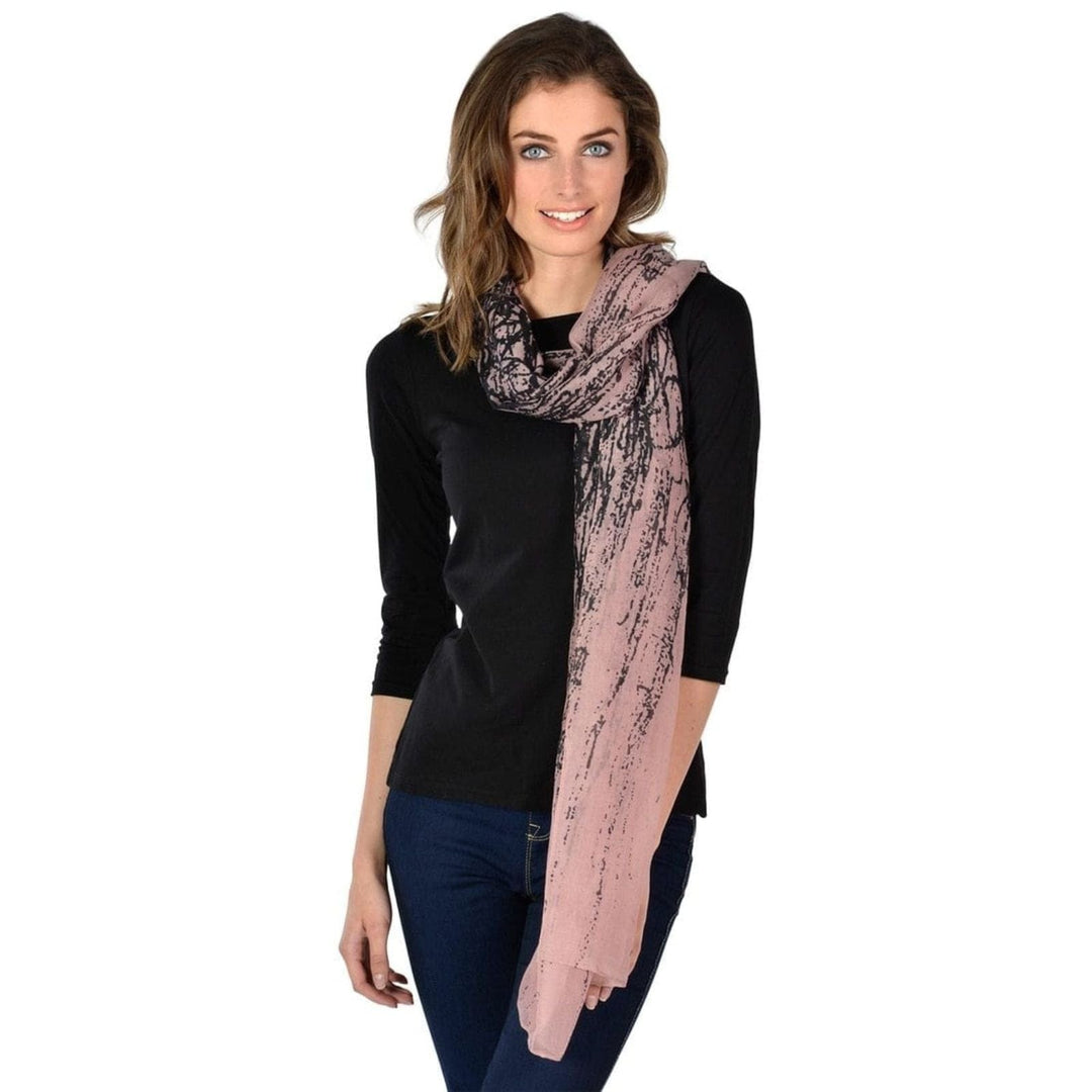 Woman wearing a pink scarf with a black abstract print on white background