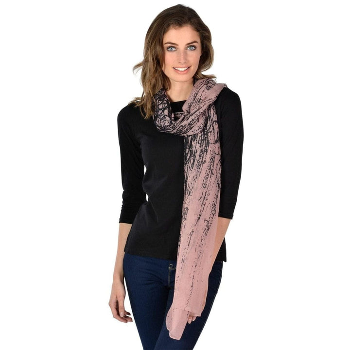 Woman wearing a pink scarf with a black abstract print on white background