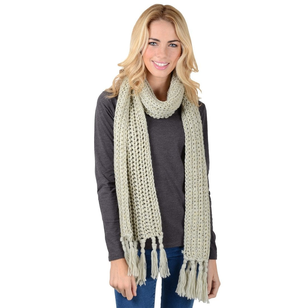 Woman wearing a long, light-colored scarf with tassels on a white background