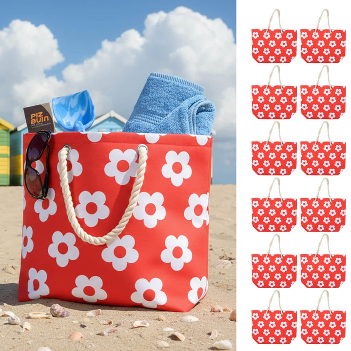 Red beach bag with white flower print and rope handles on a beach with 12 small beach bags down one side