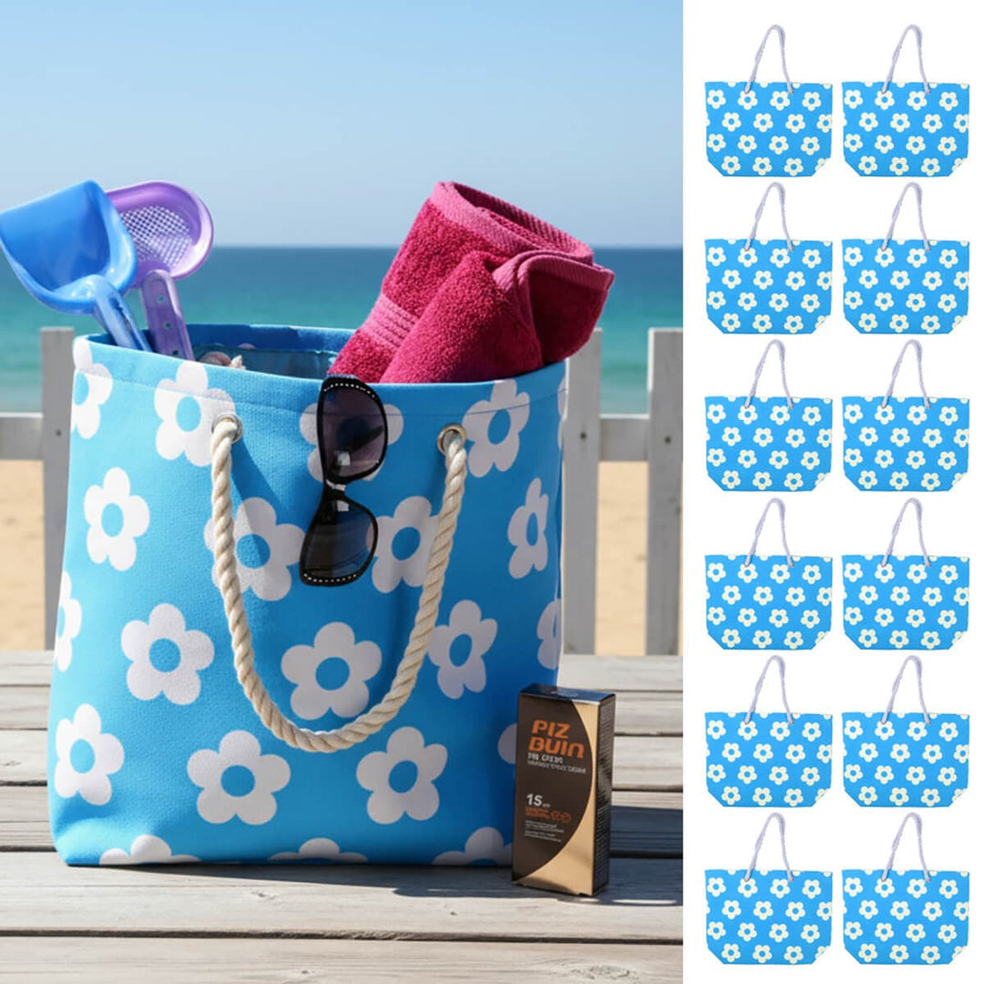Bright blue beach bag with white flower print and rope handles at the seaside with 12 small beach bags down one side