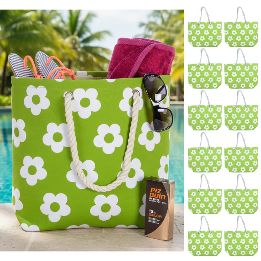 Green beach bag with white flower print and rope handles beside a swimming pool with 12 small beach bags down one side