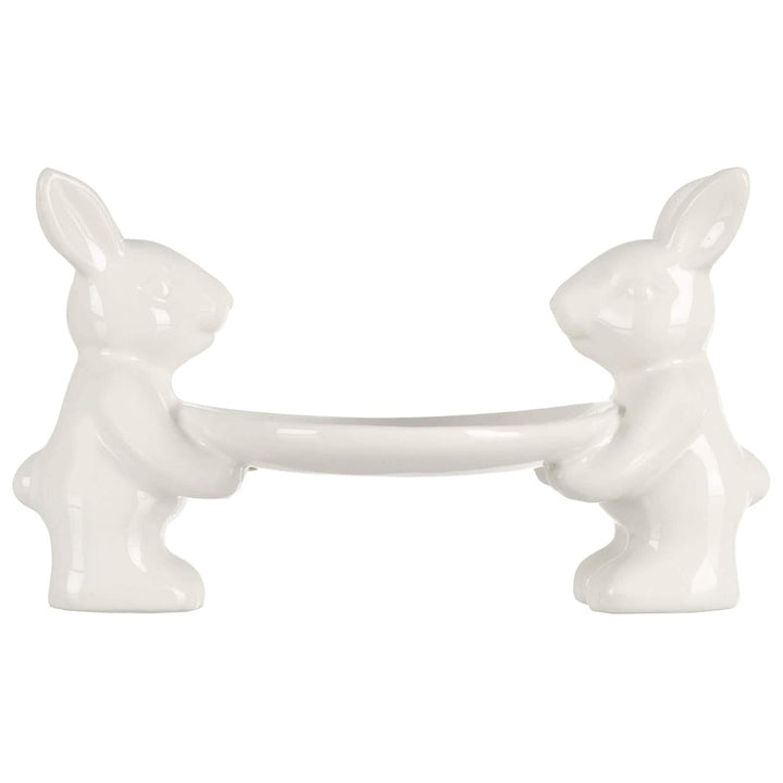 2 white Easter rabbits holding a cake plate on a white background
