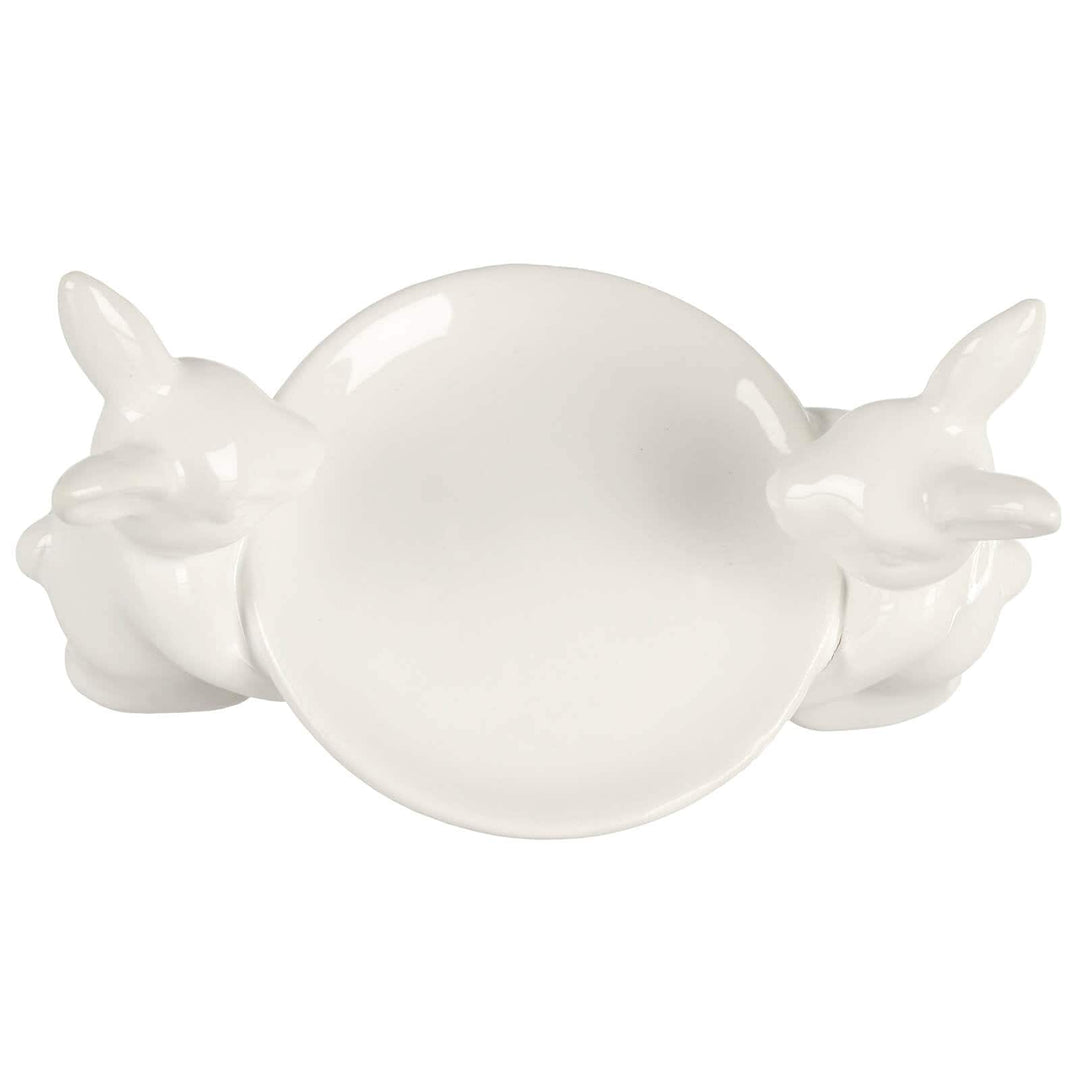 Overhead view of a white cake plate with 2 white rabbits