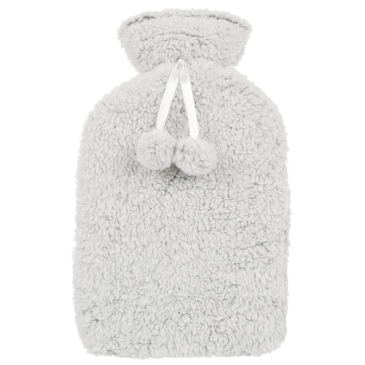 Hot water bottle with thick grey sherpa fleece cover with pom poms on a white background