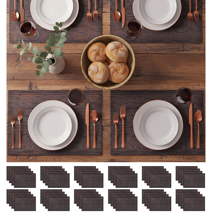 Dining table setting with white plates, bronze cutlery, and dark placemats.
