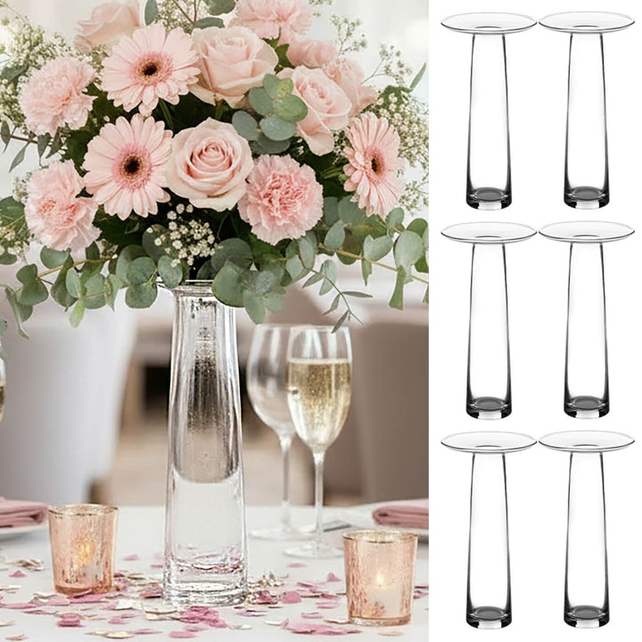 Bouquet of pink flowers in a clear vase on a wedding tbale with 6 vases down one side.