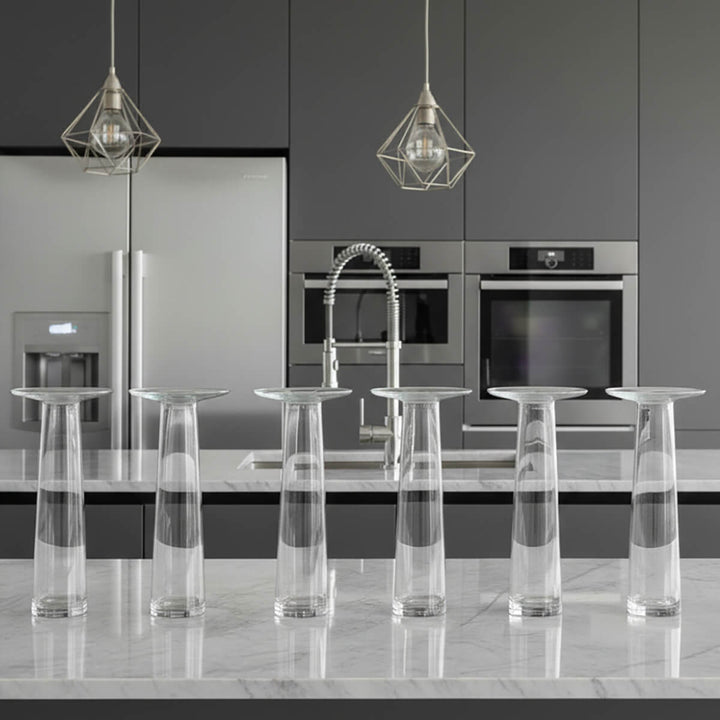 6 clear glass flower vases on a modern kitchen worktop