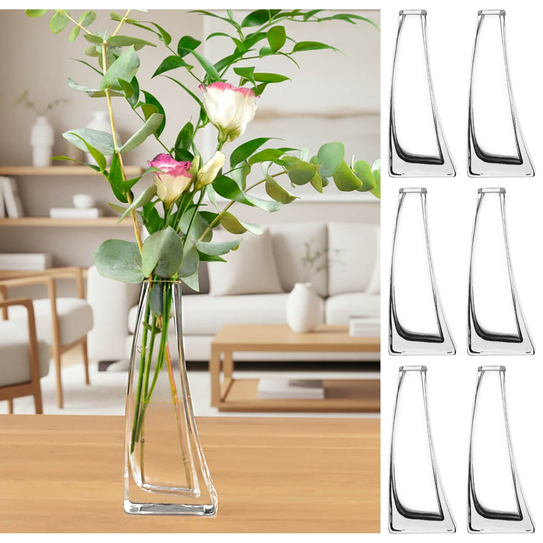 Clear glass vase with flowers on a wooden table in a living room setting, with additional clear glass vases displayed.
